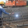 Làm cốt thép cọc móng thi công cầu An Hữu thuộc dự án đường dẫn cầu Mỹ Thuận 2 phía Tiền Giang từ nguồn vốn đầu tư công. (Ảnh: Minh Trí-TTXVN)