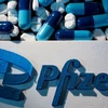 Logo Pfizer được đặt gần các viên thuốc của hãng. (Ảnh: Reuters.)
