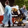 Nhân viên y tế chuyển bệnh nhân COVID-19 tại bệnh viện ở Melbourne, Australia. (Ảnh: AFP/TTXVN) 