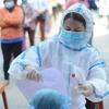 Nhân viên y tế hướng dẫn người dân thực hiện xét nghiệm COVID-19 tại một điểm xét nghiệm ở phường Phước Mỹ (Đà Nẵng). (Ảnh: Văn Dũng/TTXVN) 