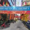 Khu phố 3, hẻm 100 đường Trần Hưng Đạo (Quận 1), nổi bật với nền tường màu vàng kèm các tiểu cảnh tranh trí Tết. (Ảnh: Thu Hương/TTXVN) 