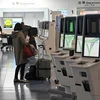 Hành khách làm thủ tục tại sân bay Haneda ở thủ đô Tokyo, Nhật Bản, ngày 1/12/2021. (Ảnh: AFP/TTXVN) 