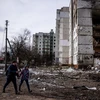 Người dân bên ngoài một khu nhà bị hư hại trong chiến sự tại Ukraine, hôm 4/3. (Ảnh: AFP.)