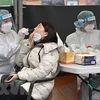 Nhân viên y tế lấy mẫu xét nghiệm COVID-19 cho người dân tại Seoul, Hàn Quốc. (Ảnh: AFP/TTXVN) 