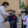 Đo thân nhiệt phòng lây nhiễm COVID-19 tại một trường học ở Bình Nhưỡng. (Nguồn: AFP/TTXVN)