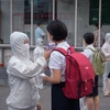 Kiểm tra thân nhiệt nhằm ngăn chặn sự lây nhiễm của dịch COVID-19 tại một trường học ở Bình Nhưỡng, Triều Tiên. (Ảnh: AFP/TTXVN)