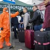 Nhân viên y tế kiểm tra thân nhiệt hành khách đi qua cửa khẩu biên giới Đức-Ba Lan. (Nguồn: AFP/TTXVN)