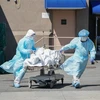 Nhân viên y tế chuyển thi thể bệnh nhân COVID-19 tại New York (Mỹ). (Ảnh: AFP/TTXVN) 