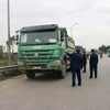 Lực lượng Thanh tra giao thông vận tải xử lý xe chở hàng quá tải trọng lưu thông qua cầu Thăng Long. (Ảnh: CTV/Vietnam+) 