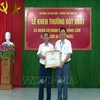 Ông Nguyễn Văn Trung (phải) nhận Bằng khen của Chủ tịch UBND tỉnh Nghệ An vì hành động dũng cảm cứu người đuối nước. (Nguồn:Tá Chuyên/TTXVN) 