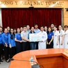 Đoàn thanh niên TTXVN trao bảng tượng trưng 70 suất quà và hơn 300 đầu sách cho Khoa Nhi - Bệnh viện K (cơ sở 3). (Ảnh: Minh Đức/TTXVN) 