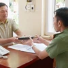 Ông Nguyễn Hữu Hùng mang chiếc ví nhặt được đến phòng Trực ban của Công an tỉnh Đắk Lắk trình báo, giao nộp. (Ảnh: TTXVN phát)