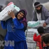 Người tị nạn Syria nhận hàng viện trợ tại trại tị nạn ở thị trấn Mehmediye, Syria. (Ảnh: AFP/TTXVN) 