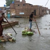 Người dân ở thành phố Hyderabad, tỉnh Sindh, đông nam Pakistan, vượt qua nước lũ trên những chiếc bè tự chế hôm 24/8. Ảnh: Reuters. 