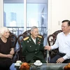 Bí thư Thành ủy Hà Nội Đinh Tiến Dũng thân mật thăm hỏi gia đình Anh hùng La Văn Cầu. (Ảnh: TTXVN)