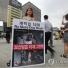 Một nhà hoạt động cầm biểu ngữ kêu gọi người dân Hàn Quốc dừng ăn thịt chó. (Nguồn: Yonhap) 