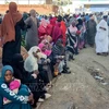 Người dân xếp hàng chờ nhận hàng cứu trợ tại Gedaref, Sudan, ngày 30/12/2023. (Ảnh: AFP/TTXVN)