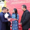 Đại sứ Việt Nam tại Algeria Trần Quốc Khánh trao giấy chứng nhận cho kiều bào có những đóng góp tích cực trong hoạt động của Hội kiều bào Việt Nam tại Algeria. (Ảnh: TTXVN)