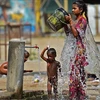 Người dân giải nhiệt tại một vòi nước công cộng trong thời tiết nắng nóng tại Allahabad, Ấn Độ, ngày 28/4/2022. (Ảnh: AFP/TTXVN) 