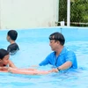 Giáo viên hướng dẫn kỹ thuật bơi cho thiếu nhi. (Ảnh: Lê Thúy Hằng/TTXVN)