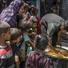 Các em nhỏ chờ được phát thức ăn cứu trợ tại trại tị nạn Jabalia, Dải Gaza. (Ảnh: THX/TTXVN)