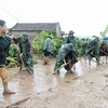 Phóng viên Danh Lam, Cơ quan thường trú Bắc Giang, tác nghiệp tại hiện trường khắc phục hậu quả mưa lũ tại thôn Khả Lã, xã Tân Lập, Lục Ngạn, Bắc Giang. (Ảnh: TTXVN)