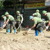 Hàng trăm người gồm bộ đội, công an, dân quân tự vệ, đoàn thanh niên... được huy động hỗ trợ dọn bùn, giúp người dân thành phố Yên Bái sớm ổn định cuộc sống sau đợt lũ. (Ảnh: Tuấn Anh/TTXVN)