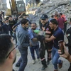 Người Palestine mang thi thể của một đứa trẻ được tìm thấy trong đống đổ nát của một ngôi nhà bị phá hủy trong các cuộc không kích của Israel ở thị trấn Beit Lahiya. (Ảnh: AP)