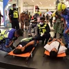 Nhân viên cấp cứu chăm sóc các nạn nhân trong vụ tai nạn tàu cao tốc, tại ga Kampung Baru hôm 24/5. (Nguồn: straitstimes.com)
