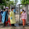 Người dân được khử khuẩn trước khi vào tiêm chủng vaccine ngừa COVID-19 tại Phnom Penh, Campuchia, ngày 20/5/2021. (Ảnh: AFP/TTXVN)