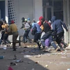 Các đối tượng cướp phá tại một cửa hàng ở Johannesburg (Nam Phi) ngày 12/7/2021. (Ảnh: AFP/TTXVN)