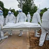 Các tình nguyện viên chôn cất thi thể bệnh nhân COVID-19 tại Kuala Lumpur (Malaysia), ngày 15/6/2021. (Ảnh: AFP/TTXVN)