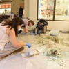 Nhân viên của Bảo tàng Khảo cổ học Beirut tại Đại học American thu nhặt mảnh vụn của các bình thủy tinh bị vỡ trong vụ nổ tại cảng Beirut, hồi tháng 8/2020. (Nguồn: theartnewspaper.com)