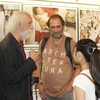 Nhiếp ảnh gia Jindřich Štreit (trái) giao lưu với khách tham quan tại triển lãm "Vietnam Stories". (Ảnh: Hồng Kỳ/TTXVN)