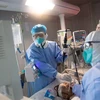 Nhân viên y tế điều trị cho bệnh nhân COVID-19 tại một bệnh viện ở Hồ Bắc (Trung Quốc). (Ảnh: AFP/TTXVN)