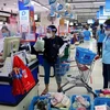 Hội viên Hội Liên hiệp phụ nữ Thành phố Hồ Chí Minh đi chợ giúp người dân mua hàng hóa, lương thực tại siêu thị Co.op Nhiêu Lộc-Thị Nghè. (Ảnh: Thanh Vũ/TTXVN)
