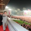 Nhà lãnh đạo Triều Tiên Kim Jong-un vẫy chào các binh sỹ, khán giả và những người tham gia cuộc diễu hành. (Nguồn: aljazeera.com)