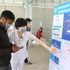 Nhân viên Bệnh viện Đa khoa tỉnh Kon Tum hỗ trợ người dân khai báo y tế và quét mã QR trên ứng dụng VietNam Health Declaration. (Ảnh: Dư Toán/TTXVN)
