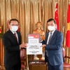 Đại sứ Việt Nam tại Singapore Mai Phước Dũng (phải) tiếp nhấn tượng trưng lô hàng do Quỹ Temasek trao tặng. (Ảnh: Lê Dương/TTXVN)