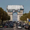 Các công nhân phủ vải lên Khải Hoàn Môn theo ý tưởng sắp đặt của cố nghệ sỹ Christo trên đại lộ Champs Elysee ở thủ đô Paris (Pháp), ngày 12/9/2021. (Nguồn: Reuters)