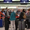 Hành khách chờ đợi tại quầy làm thủ tục ở sân bay quốc tế Sydney (Australia), ngày 19/4/2021. (Ảnh: AFP/TTXVN)