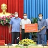 Bí thư Thành ủy Thành phố Hồ Chí Minh Nguyễn Văn Nên (thứ hai từ trái sang) trao tặng 3 tỷ đồng hỗ trợ An Giang phòng, chống dịch COVID-19. (Ảnh: Thanh Sang/TTXVN)