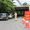Lực lượng chức năng Phú Thọ hướng dẫn chủ phương tiện dừng đỗ vào khai báo y tế trước khi vào tỉnh, hồi tháng 7/2021. (Ảnh: Trung Kiên/TTXVN)