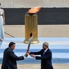 Giám đốc Ủy ban Olympic Hy Lạp Spyros Kapralos (trái) trao ngọn đuốc Olympic cho Phó Chủ tịch Ban tổ chức Olympic Bắc Kinh 2022 Yu Zaiqing tại sân vận động Panathenaic ở Athens, ngày 19/10/2021. (Ảnh: AFP/TTXVN)