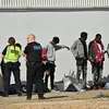 Người di cư chờ cảnh sát thẩm vấn sau khi họ tìm cách vượt eo biển Manche từ Pháp sang Anh, ngày 7/9/2021. (Ảnh: AFP/TTXVN)