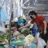 Người mua và người bán thực hiện thông điệp 5K của Bộ Y tế về phòng chống dịch tại chợ Phùng Khoang. (Ảnh: Vũ Sinh/TTXVN)