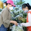 Người dân lựa chọn hàng hóa, thực phẩm tại "Chợ 0 đồng." (Ảnh: Nguyễn Thanh/TTXVN)