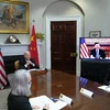 Tổng thống Mỹ Joe Biden (thứ hai, trái) và Chủ tịch Trung Quốc Tập Cận Bình (trên màn hình) tại hội nghị thượng đỉnh trực tuyến, ở Nhà Trắng, Washington, D.C. (Mỹ), hồi giữa tháng 11/2021. (Ảnh: AFP/TTXVN)
