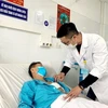 Bác sỹ thăm khám bệnh nhân sau khi hồi phục. (Ảnh: TTXVN)