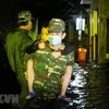 Các chiến sỹ đưa trẻ em đến nơi an toàn, khi trận triều cường chiều tối 19/12 gây ngập sâu tại khu phố Lê Duẩn ở thành phố Tuy Hòa (Phú Yên). (Ảnh: Phạm Cường/TTXVN)